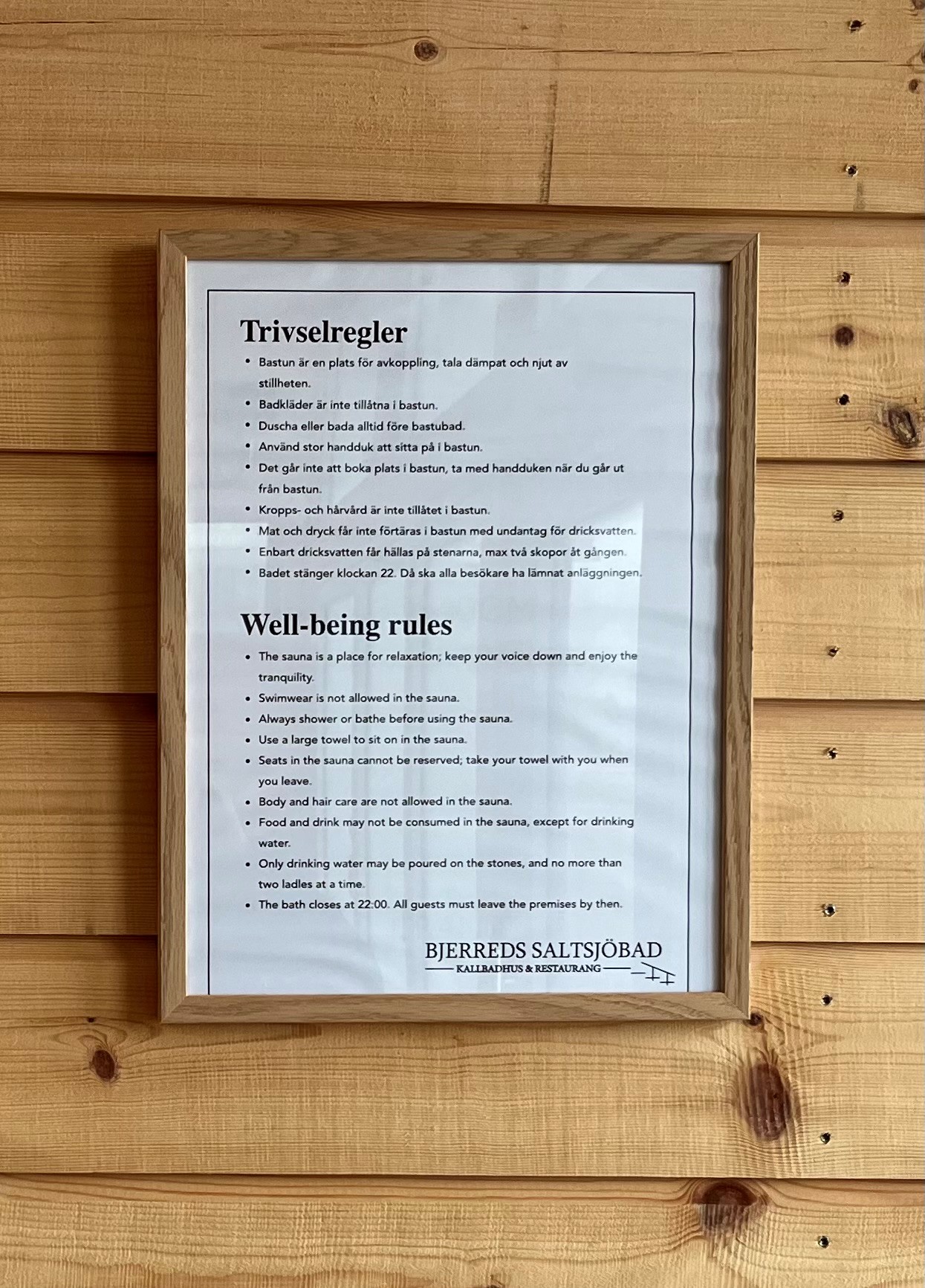 Bild på inramade trivselregler som hänger mot trävägg